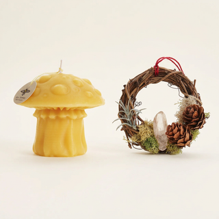 Golden beeswax mushroom candle beside a miniature crystal moss wreath ornament